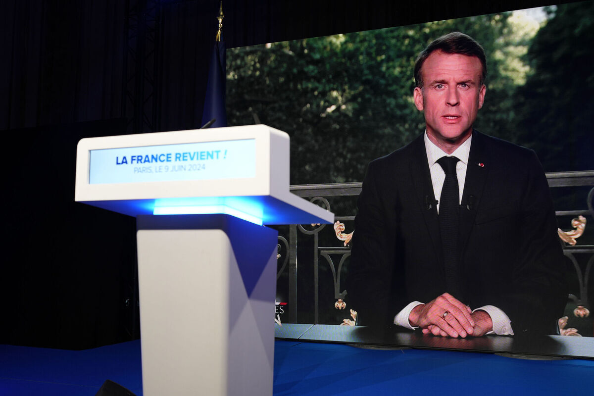 French President Emmanuel Macron appears on a television screen at the French far-right National Rally party election night headquarters on Sunday to announce the dissolution of the National Assembly and call for an election. Photo: AP/Lewis Joly