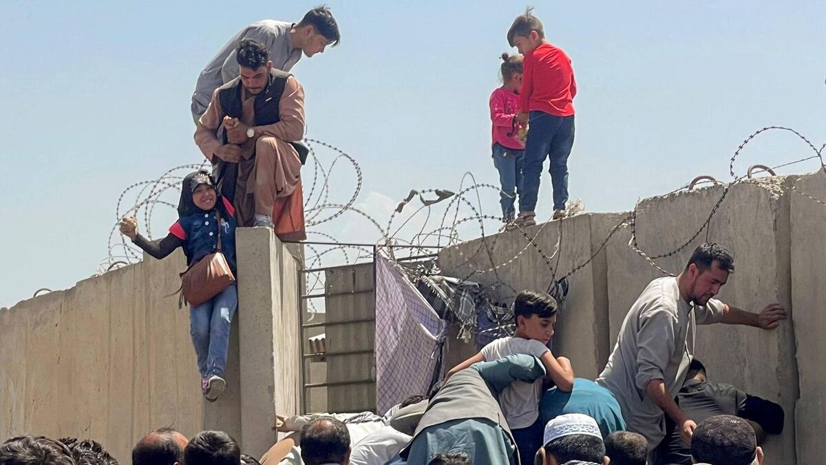 The front-page photo in the print edition of the Irish Examiner on August 17, 2021 of families scrambling to get over a security fence into the main airport in Kabul just to get away from the Taliban. Picture: Reuters/Stringer The front-page photo in the print edition of the Irish Examiner on August 17, 2021 of families scrambling to get over a security fence into the main airport in Kabul just to get away from the Taliban. Picture: Reuters/Stringer