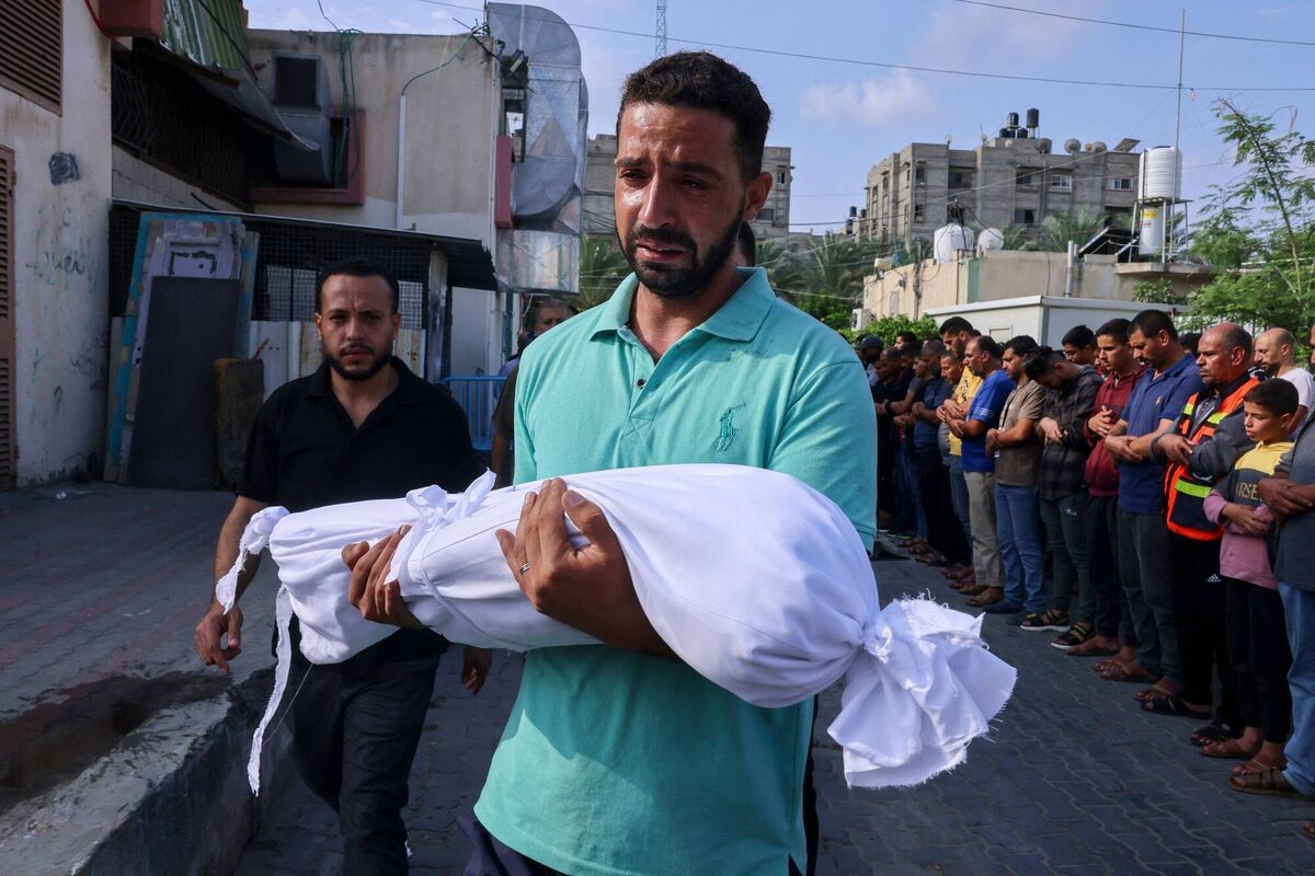 A Palestinian man carrying the body of a child killed in Israeli shelling in Khan Yunis in the southern Gaza Strip earlier that month, on October 10, 2023.  Picture: Said Khatib/AFP/Getty