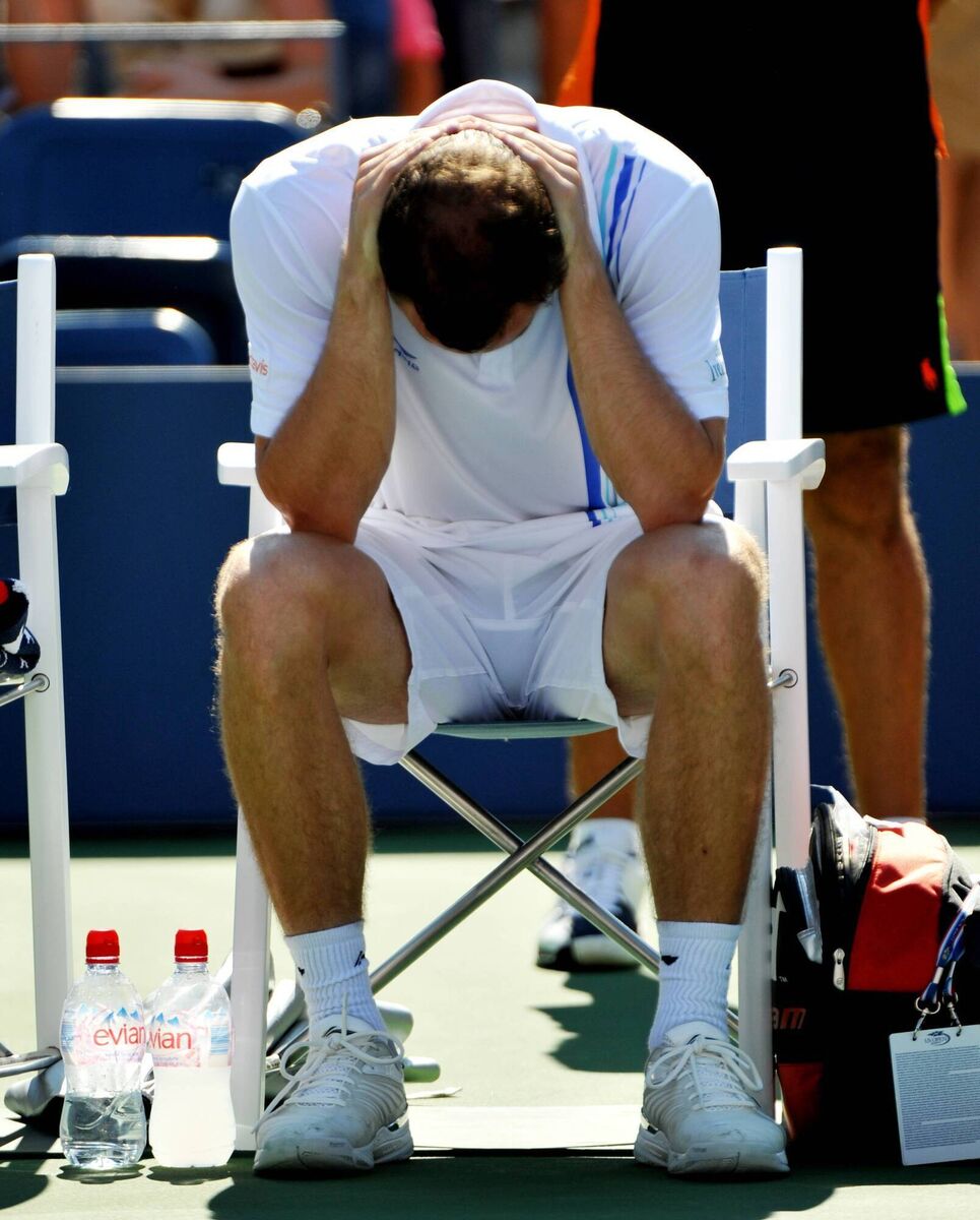Niland sits dejected at courtside after he withdrew due to illness against Djokovic at the 2011 US Open
