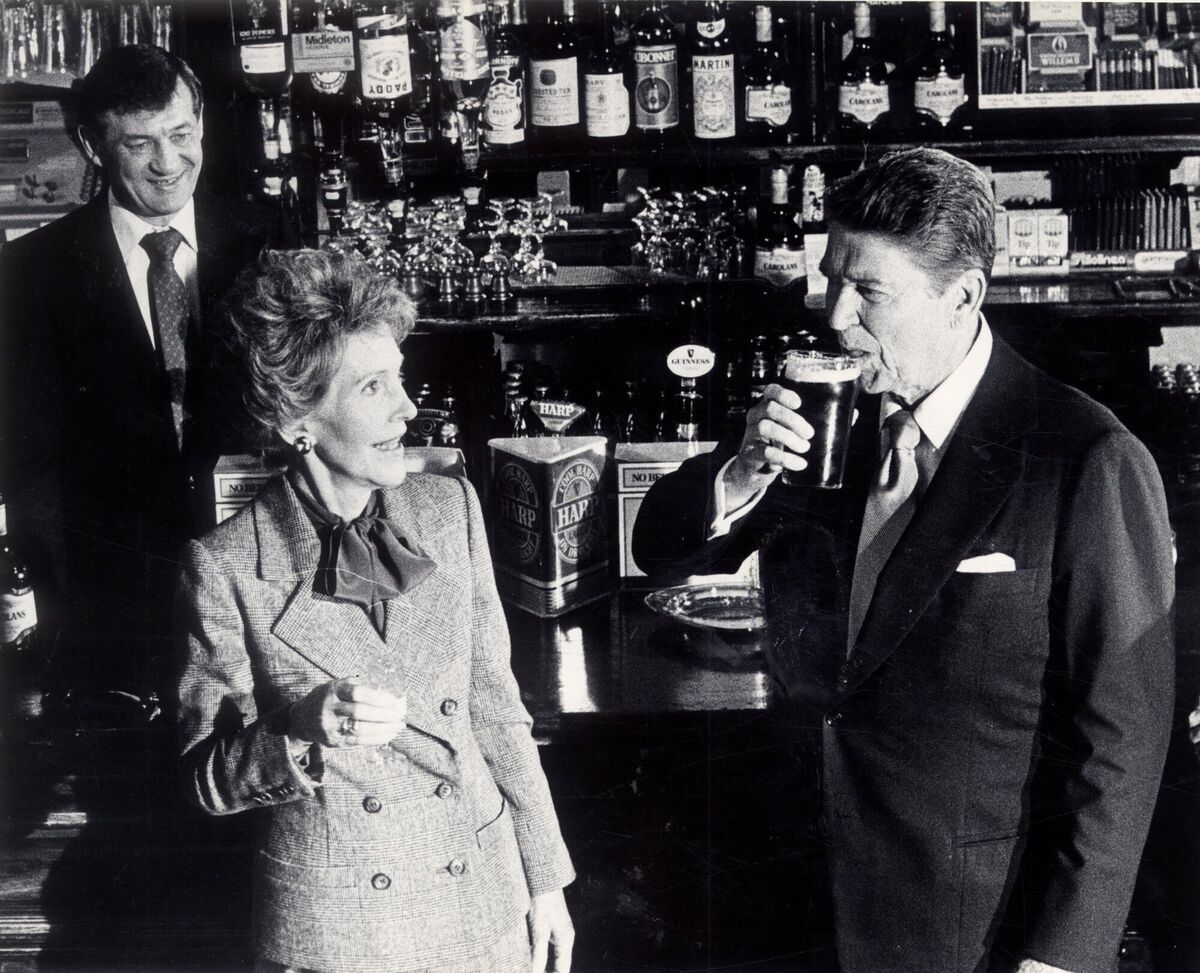 Ronald Reagan sips a pint of Smithwick's ale as Nancy Reagan looks on in Ballyporeen, Co Tipperary, during their visit To Ireland in June 1984.  Irish Examiner Archive