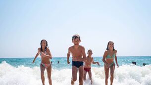 <p>children are running towards the shore at the sea in swimming trunks, running on the sand, enjoying themselves and being happy</p>