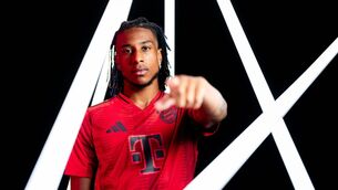<p>Michael Olise poses as he signs a contract with Bayern Munich</p>