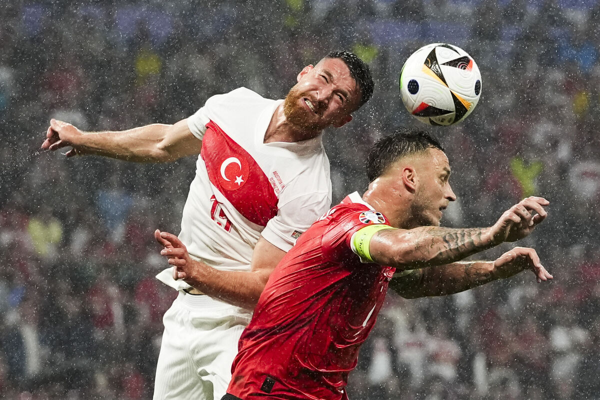 Turkey's Salih Ozcan, left, and Austria's Marko Arnautovic head the ball during their round of sixteen match