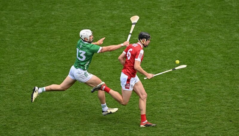 MARCHING ON: Cork's Rob Downey strides past Limerick's Aaron Gillane. Pic: Daire Brennan/Sportsfile