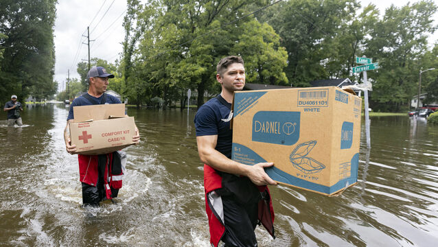 Firefighters Ron Strauss, (right) and Andrew Stevenson (left) carry food to residents in the Tremont Park area of Savannah (Stephen B Morton/AP/PA)