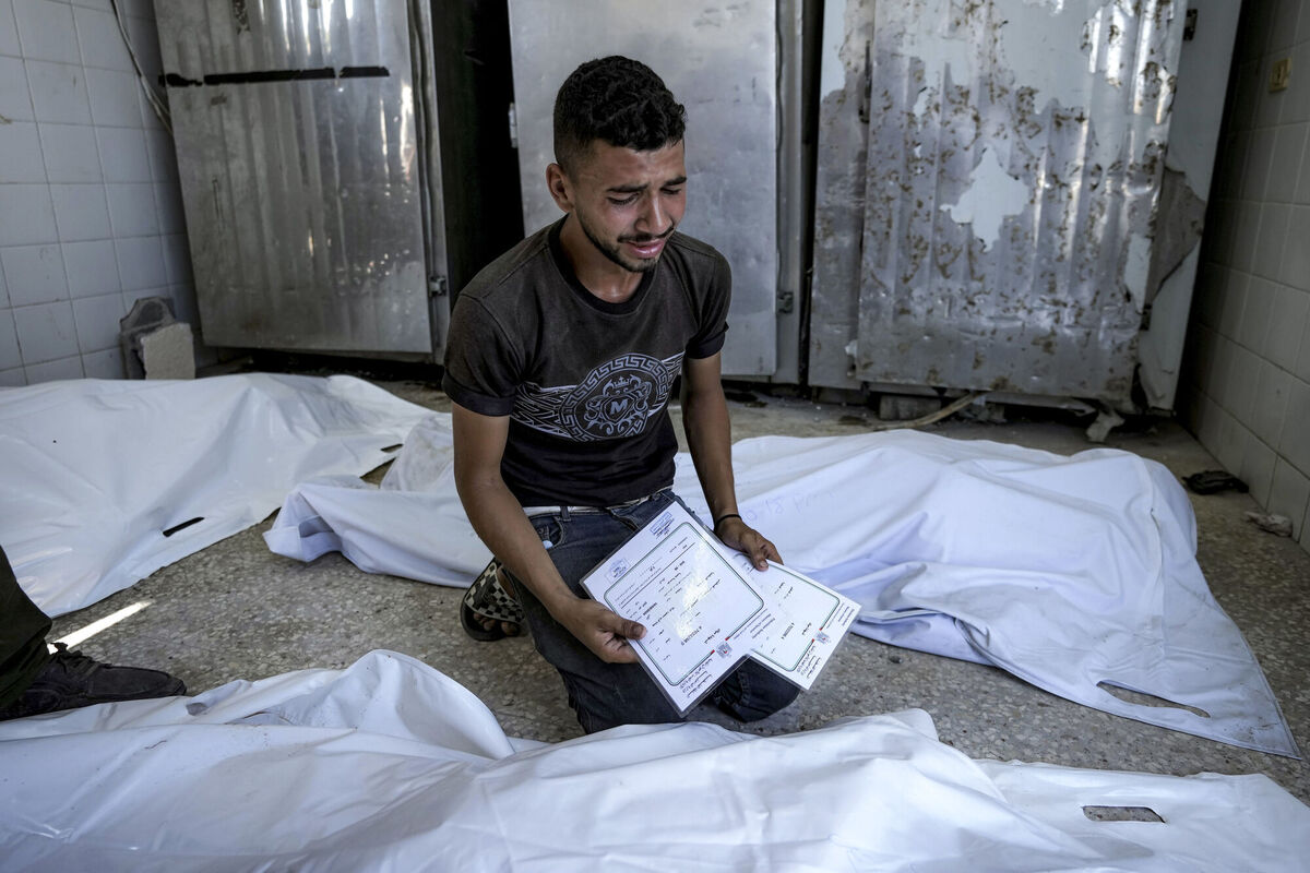 A Palestinian man mourns his 4-day-old twin relatives earlier this month. They were killed in the Israeli bombardment of the Gaza Strip, as he holds their birth certificates, at a hospital morgue in Deir al-Balah on August 13. Picture: AP Photo/Abdel Kareem Hana A Palestinian man mourns his 4-day-old twin relatives earlier this month. They were killed in the Israeli bombardment of the Gaza Strip, as he holds their birth certificates, at a hospital morgue in Deir al-Balah on August 13. Picture: AP Photo/Abdel Kareem Hana