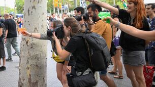 <p>A protest against mass tourism in Barcelona last month, where some participants used water pistols to spray tourists sitting in a restaurant. Picture: Adrià Puig/Anadolu/Getty </p>