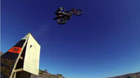 Watch a man BASE jump into a canyon from a Motocross ramp