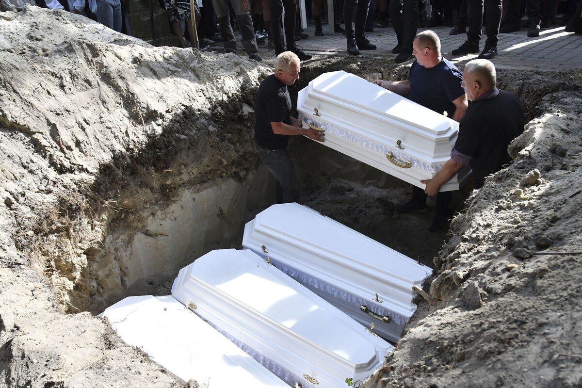 The coffins of four members of one family, Yevgenia Bazylevych and her three daughters — Daryna, 18, Emilia, 7, and Yaryna, 21 — are placed in their shared grave after all four were killed in a devastating Russian missile attack on Lviv in Ukraine on Wednesday. Picture: Mykola Tys/AP