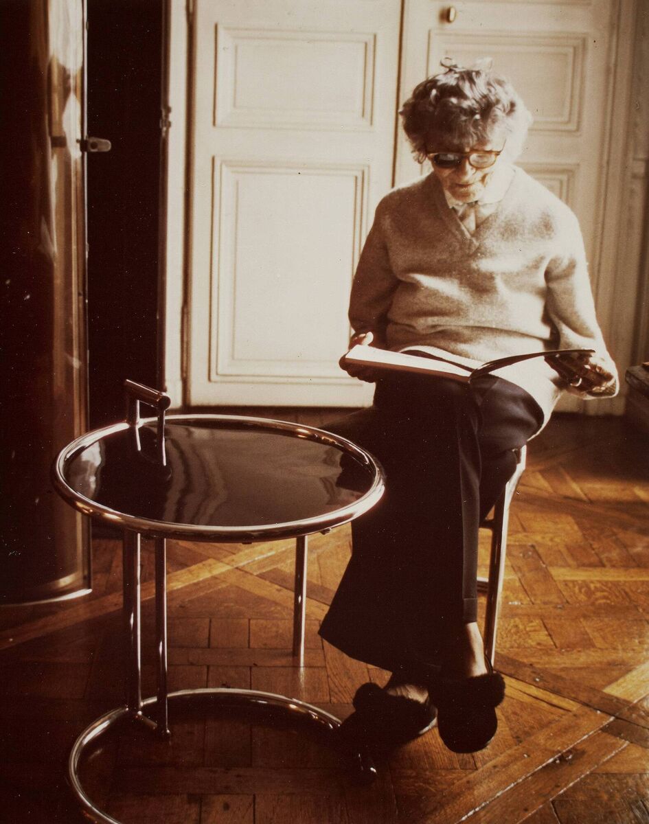 Eileen Grey relaxes with one of her signature works, the E2107 tea table, created for her house in Roquebrune-Cap-Martin (1973); Eileen Gray her Work &amp; her World by Jennifer Goff.