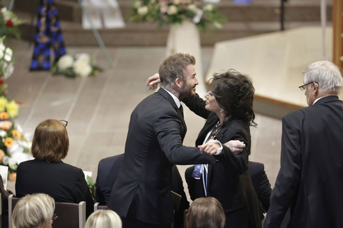 David Beckham and Nancy Dell'Olio hug as they arrive to attend the funeral service. Pic: Adam Ihse/TT News Agency via AP