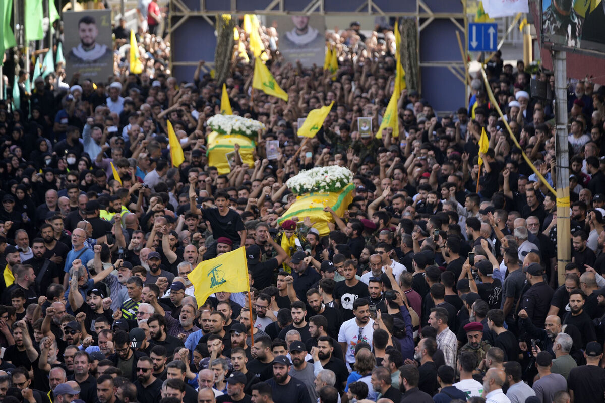 Hezbollah members carry the coffins of two of their comrades who were killed on Wednesday when a handheld device exploded, during a funeral procession in the southern suburbs of Beirut. Picture: AP Photo/Hussein Malla