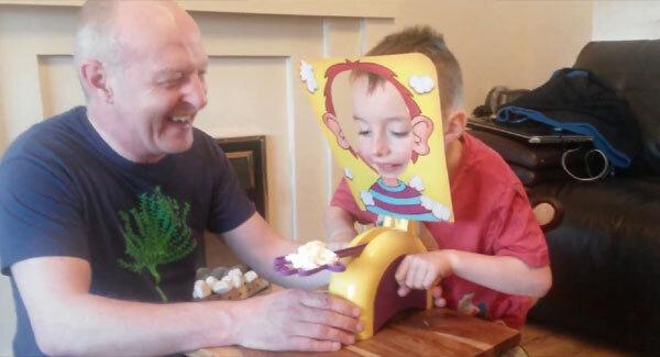 Grandad playing Pie Face game with grandson has just the best laugh