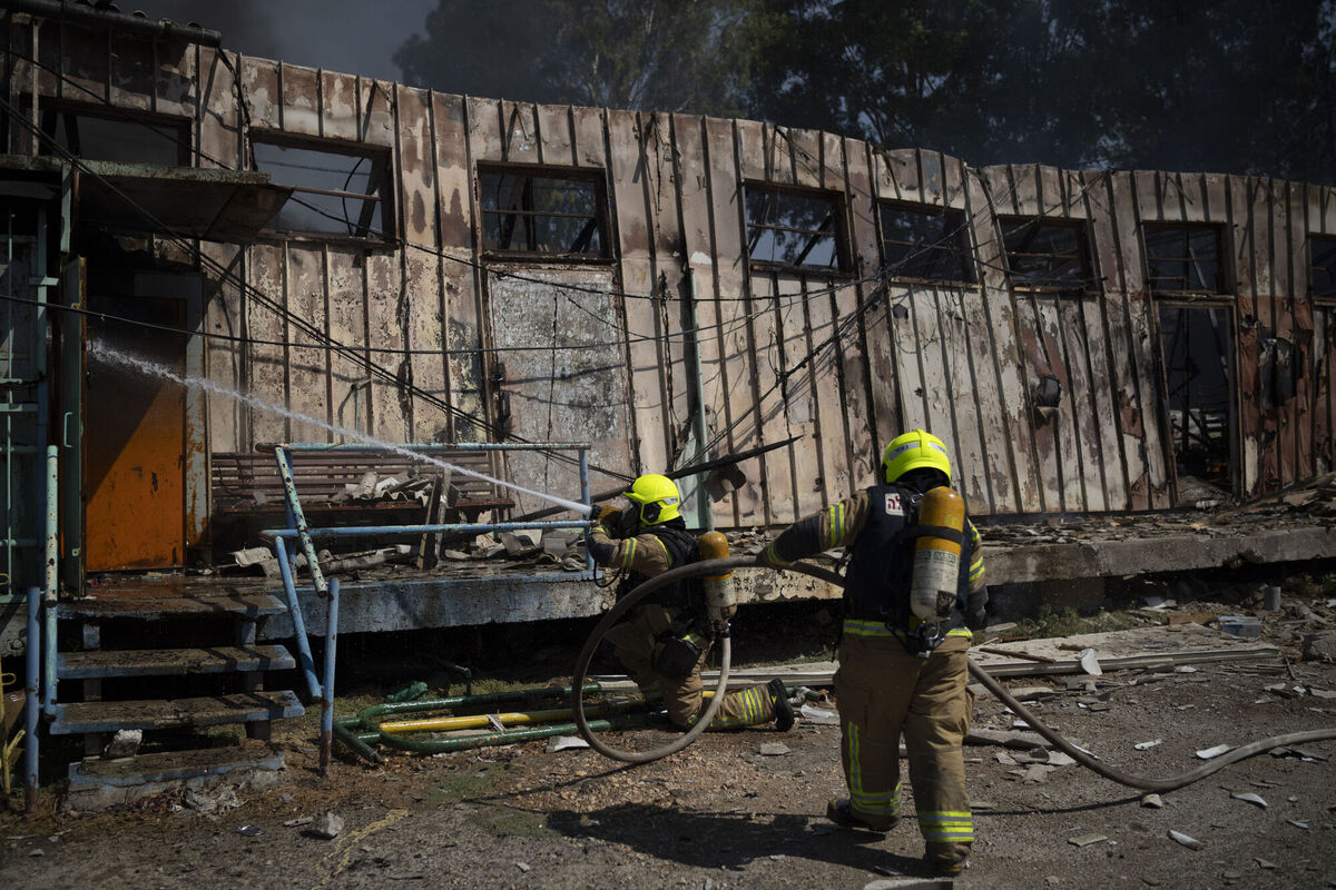 Firefighters work to extinguish a fire after a rocket, fired from Lebanon, hit a local municipality storage in Kiryat Shmona, northern Israel, Tuesday, Sept. 24, 2024. (AP Photo/Leo Correa)
