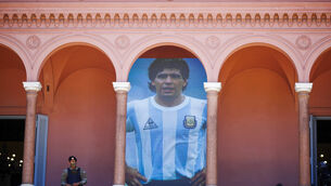 A giant poster of Diego Maradona is displayed on a balcony of the presidential palace in Buenos Aires (Marcos Brindicci/AP)