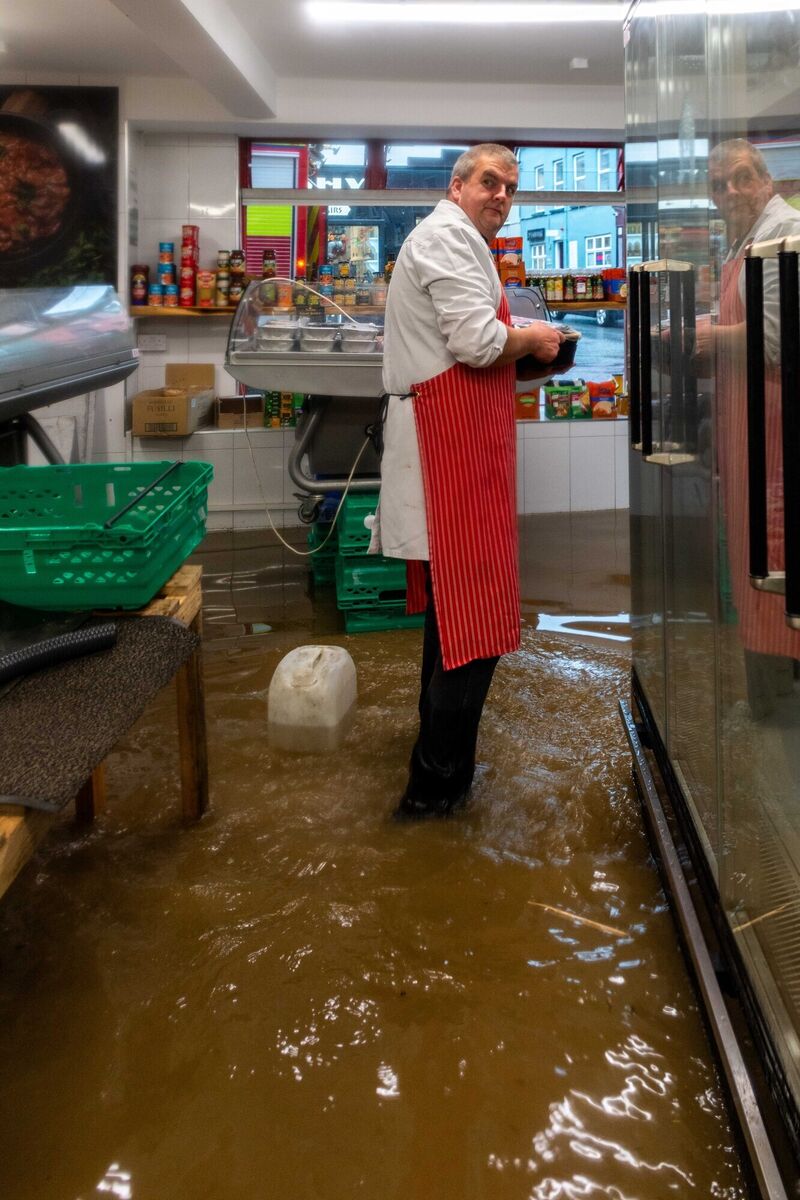 Martin Collins of Paddy O'Donoghue butchers wading through the flood waters in the shop. Picture: Andy GIbson. Martin Collins of Paddy O'Donoghue butchers wading through the flood waters in the shop. Picture: Andy GIbson.
