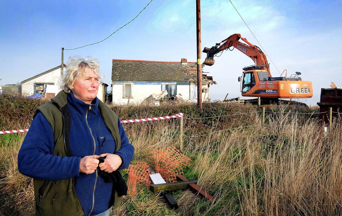 Bryony Nierop-Reading watches as her street is demolished in 2013 due to cliff falls. 