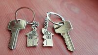 Two keys with splitted key rings with pendant in shape of house