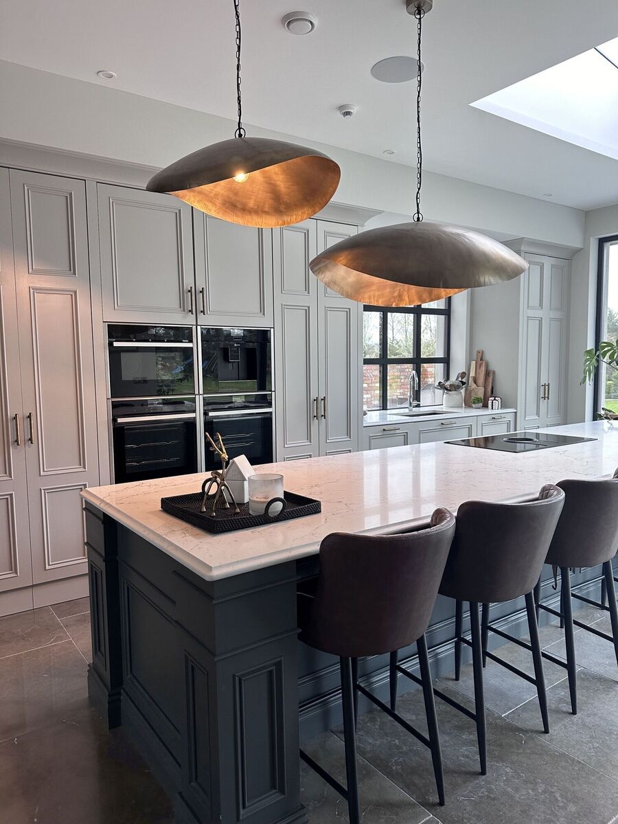  Vicki Faller's kitchen lighting includes sculptural pendants above her island, emitting a warm glow as dusk falls.
