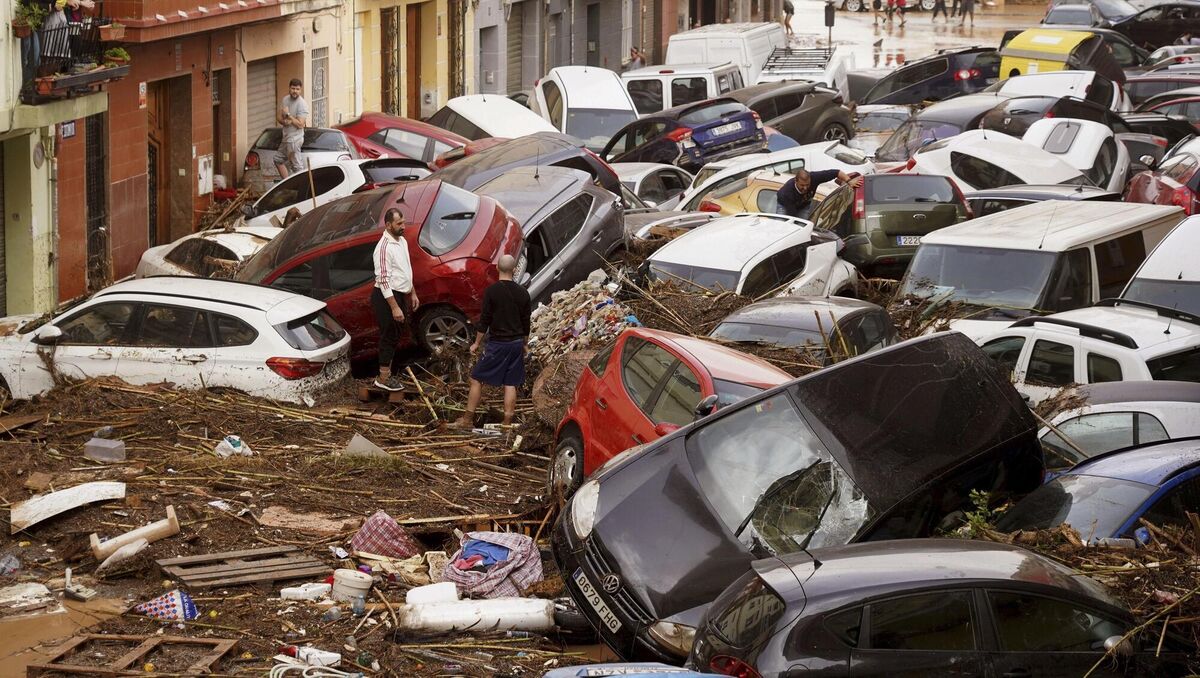 Residents look at cars piled up after being swept away by floods in Valencia, Spain, Wednesday, Oct. 30, 2024. (AP Photo/Alberto Saiz)
