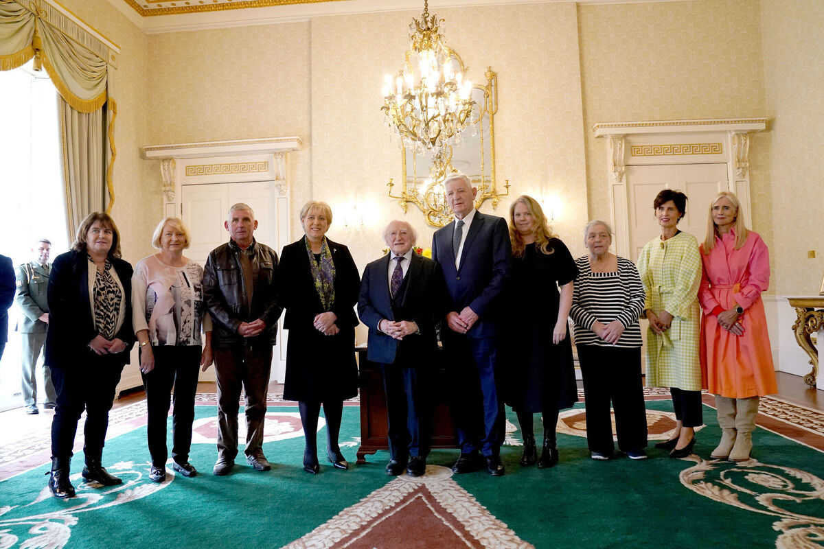 President Michael D Higgins stands with family relatives of Sylvester Poff