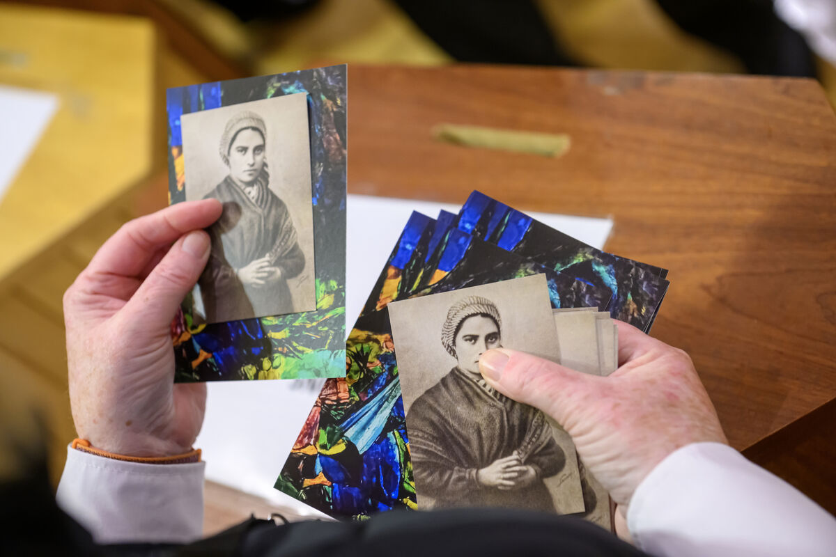 A congregant with pictures of St Bernadette of Lourdes at the Cathedral of St Mary and St Anne, Cork. Picture: Dan Linehan