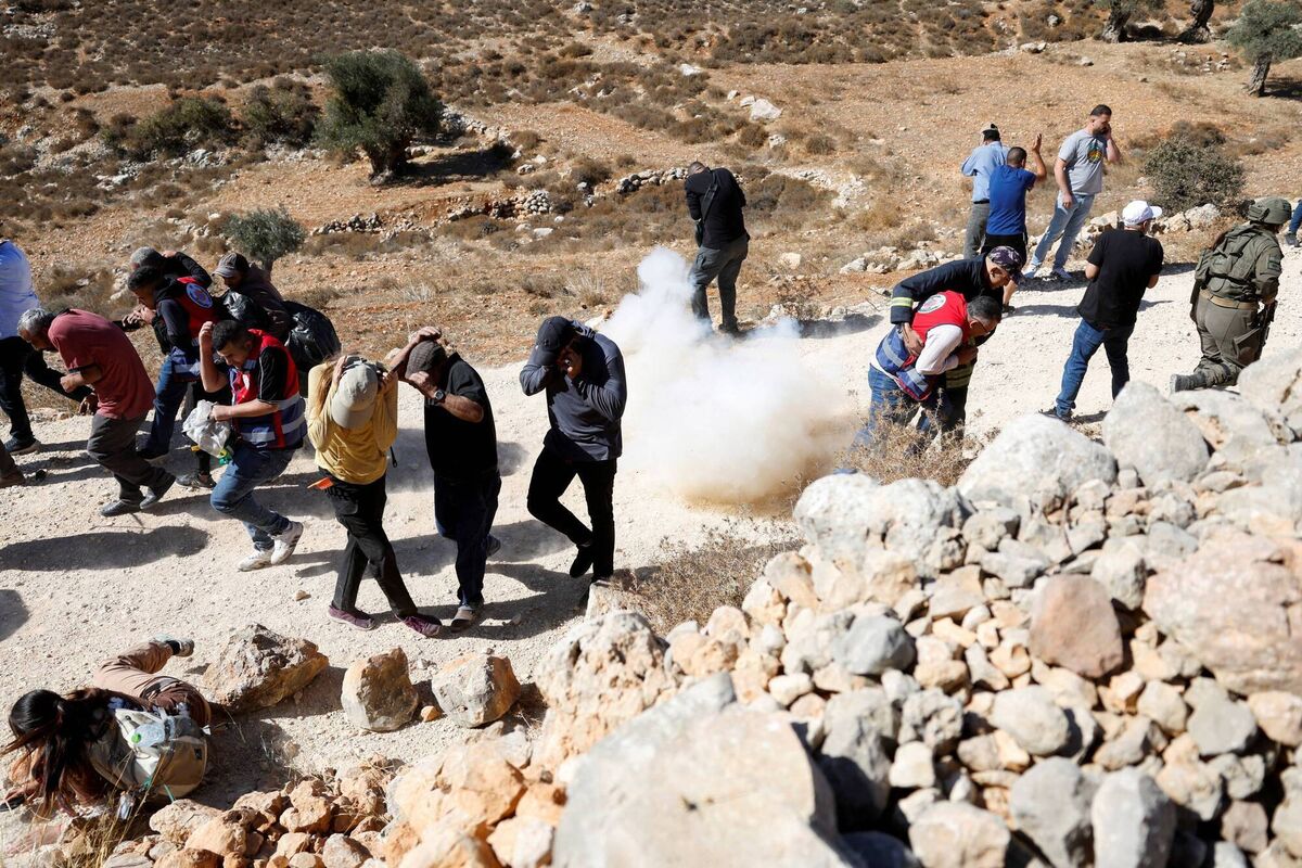 Palestinians run for cover from a stun grenade as Israeli troops deny access to farmers to harvest olives, in Burqa near Ramallah in the Israeli-occupied West Bank October 20, 2024. Picture: REUTERS/Mohammed Torokman Palestinians run for cover from a stun grenade as Israeli troops deny access to farmers to harvest olives, in Burqa near Ramallah in the Israeli-occupied West Bank October 20, 2024. Picture: REUTERS/Mohammed Torokman