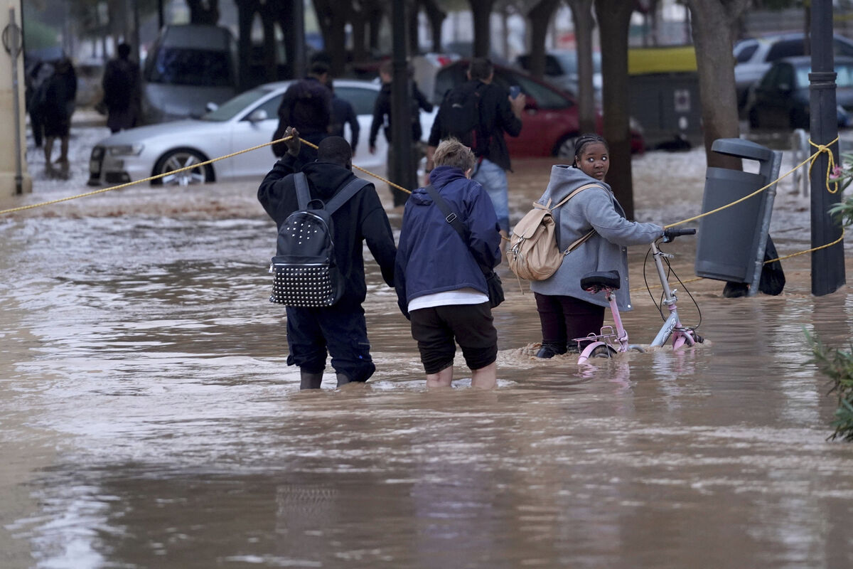 People walk through flooded streets in Valencia, Wednesday, October 30, 2024. 