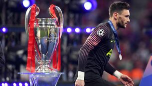 <p>HUGO LOSS: Hugo Lloris  walks past the UEFA Champions League trophy dejected after collecting his runners up medal. Pic: Matthias Hangst/Getty Images.</p>