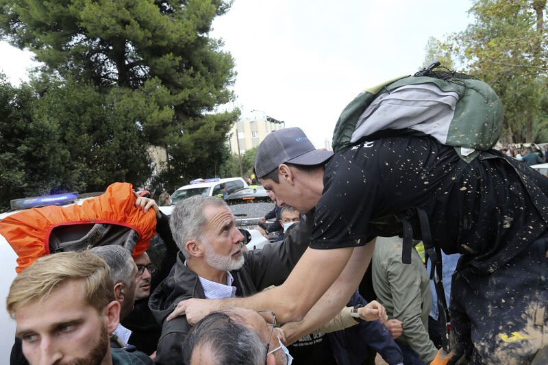 Spain's King Felipe VI listens to a person affected by the floods after a crowd of angry survivors of Spain's floods tossed mud and shouted insults at the King and government officials. Picture: AP Photo/Hugo Torres
