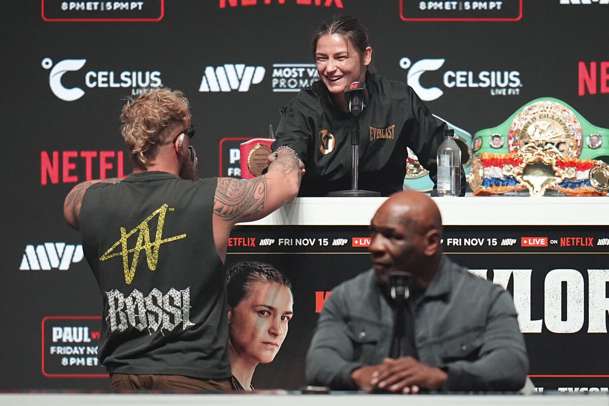 Jake Paul bets his purse with Katie Taylor as Mike Tyson looks on during a news conference ahead of their fight.