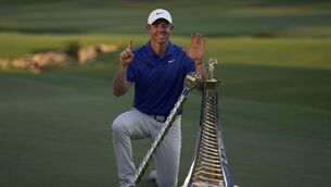 <p>GLASS HALF-FULL: Rory McIlroy poses with the DP World Tour Championship and the Race to Dubai trophies. PICTURE: AP Photo/Altaf Qadri</p>
