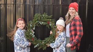 <p>Lyndsey O’Connell with her twin daughters, Martha (left) and Jane O’Connell Devine, holding their homemade Christmas wreath.</p>