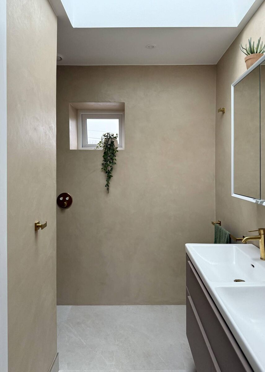 A bathroom project by Anna Maison B is finished in a warm neutral colour microcement.