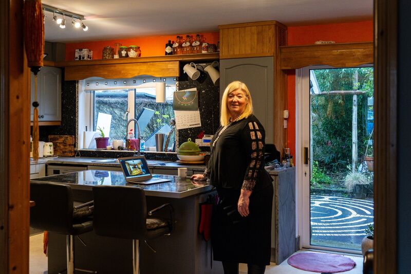 Shirley Gallagher looks through the before and after pictures on her laptop in the renovated kitchen of her Glanmire home which was devastated in floods. Picture: Chani Anderson