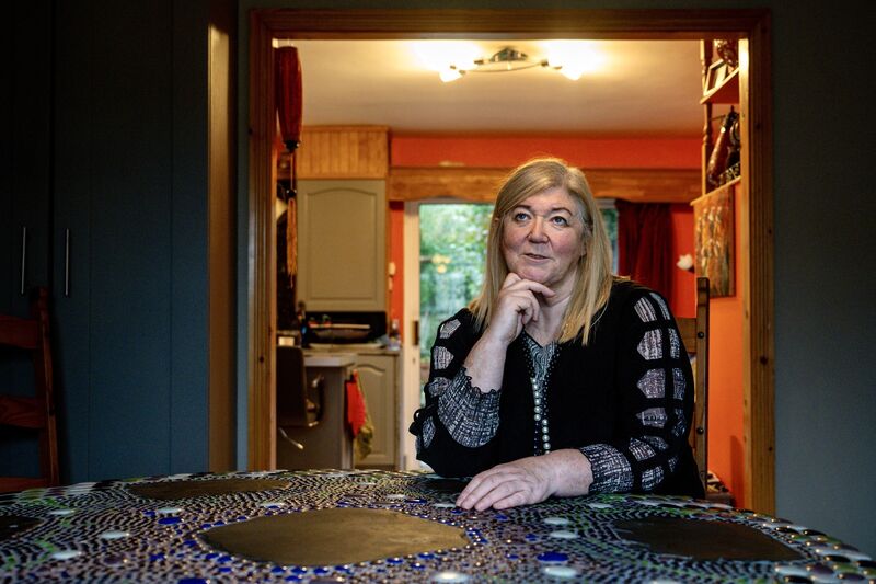 Shirley Gallagher in her renovated sitting room, now purposefully devoid of soft furnishings, replaced instead with a specially commissioned table by artist Lynn Kirkham and a collection of personal items salvaged from the deluge. Picture: Chani Anderson