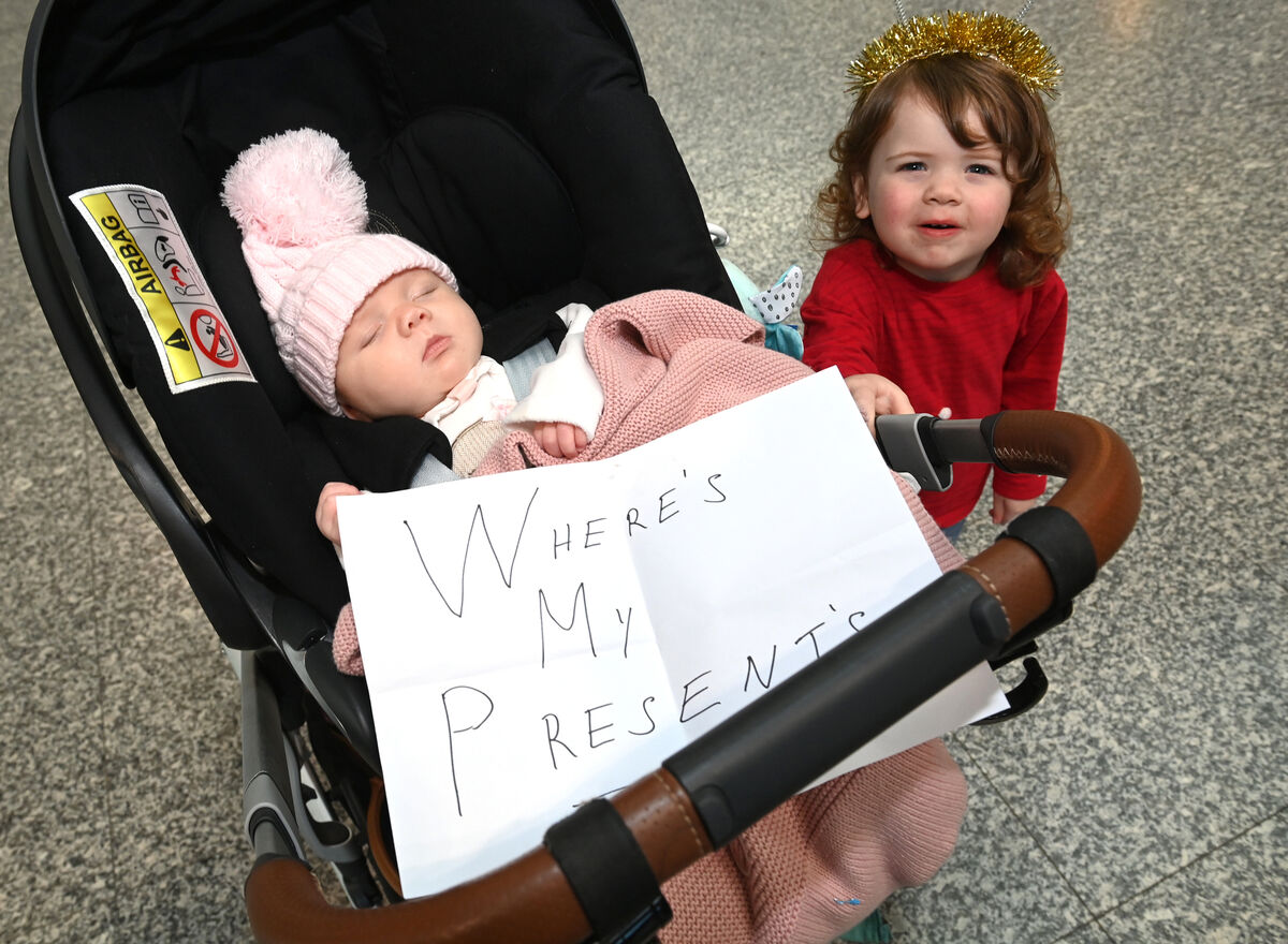 'Where's my presents?' Three-month-old Sienna Keane had a message prepared as she took a nap while her 2-year-old big sister Rosie kept an eye out for the arrival of their uncle Barry O'Donnell returning to Cork Airport from Dubai. Pictures: Larry Cummins