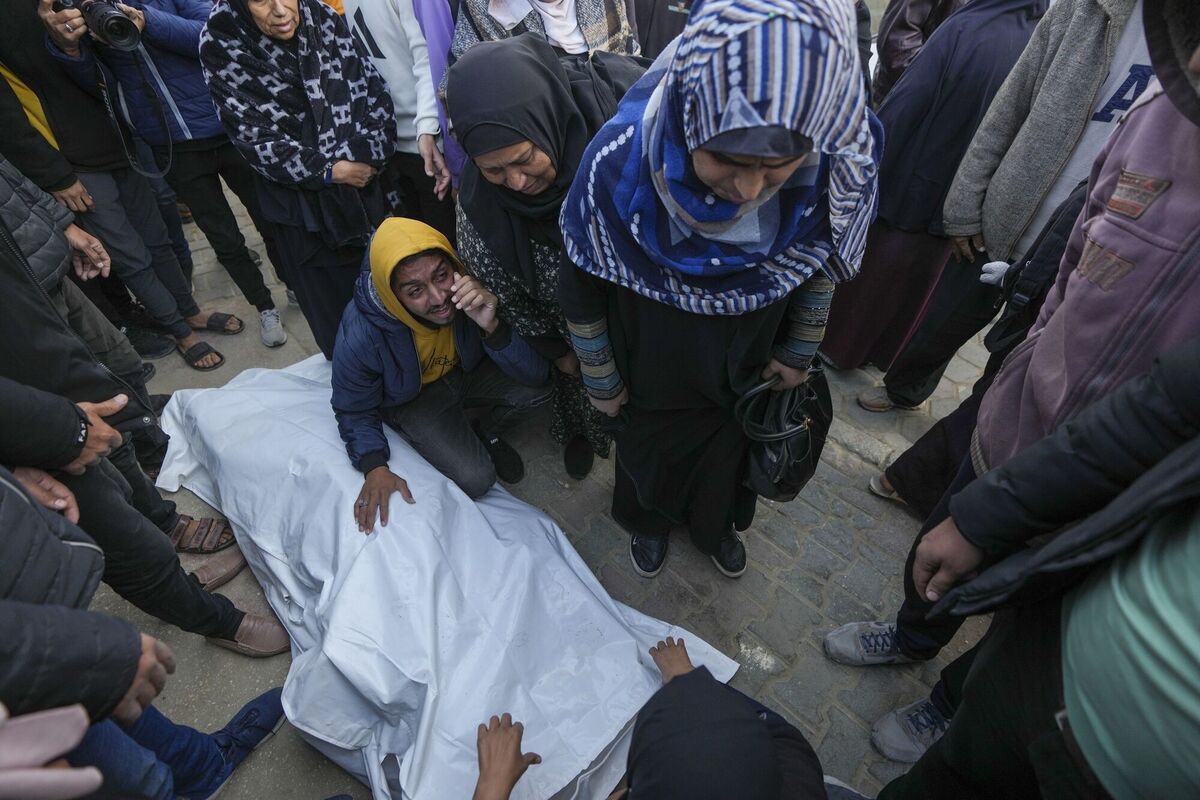 Relatives and neighbours mourn over the body of one of the victims of an Israeli strike on a home in in Deir al-Balah late on Saturday December 22, 2024. At least eight people were killed according to the hospital which received the bodies. Picture: Abdel Kareem Hana/AP