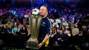 <p>Luke Littler kisses The Sid Waddell Trophy after winning the Paddy Power World Darts Championship final against Michael van Gerwen</p>