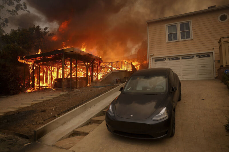 The Palisades Fire burns a structure in the Pacific Palisades neighborhood of Los Angeles, Wednesday, Jan. 8, 2025. (AP Photo/Etienne Laurent)