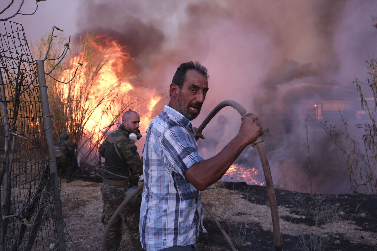 A volunteer battles a wildfire in northern Athens, Greece, in August. Photo: AP/Aggelos Barai A volunteer battles a wildfire in northern Athens, Greece, in August. Photo: AP/Aggelos Barai