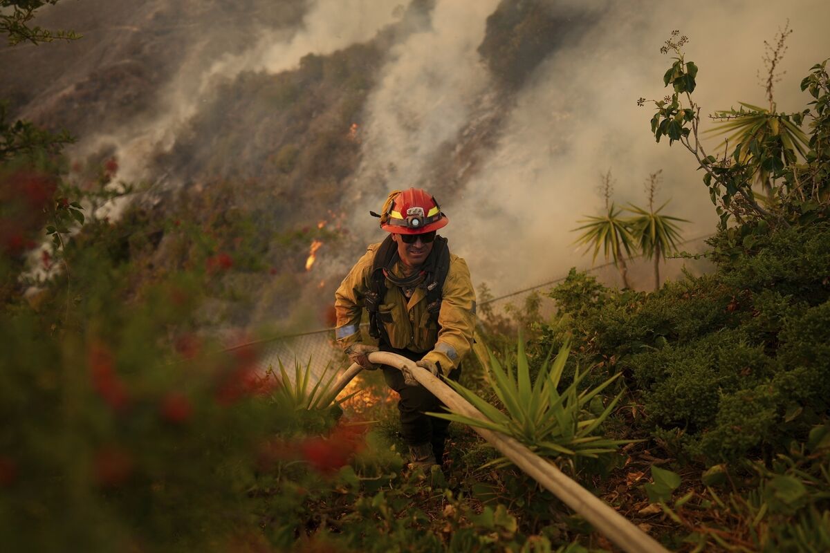 A firefighter sets up a hose while fighting the Palisades Fire. Picture: AP Photo/Eric Thayer A firefighter sets up a hose while fighting the Palisades Fire. Picture: AP Photo/Eric Thayer