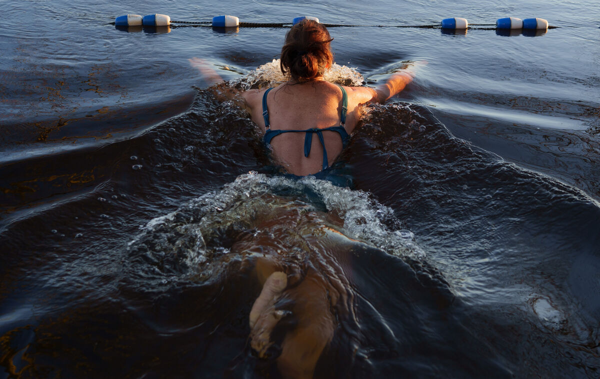 Helen takes a dip into the icy cold river after sauna, where temperatures can reach 100C.