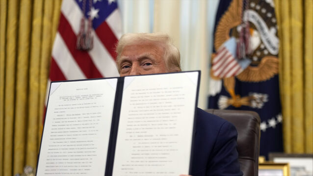 Donald Trump holds a signed executive order regarding the declassification and release of records relating to the assassinations of John F Kennedy, Robert F Kennedy and Martin Luther King Jr (Ben Curtis/AP)