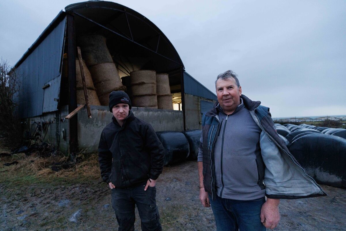 John Burke and his son Eoin Burke with their barn in Fanore, North Clare, that lost its side wall during Storm Éowyn. Picture: Eamon Ward