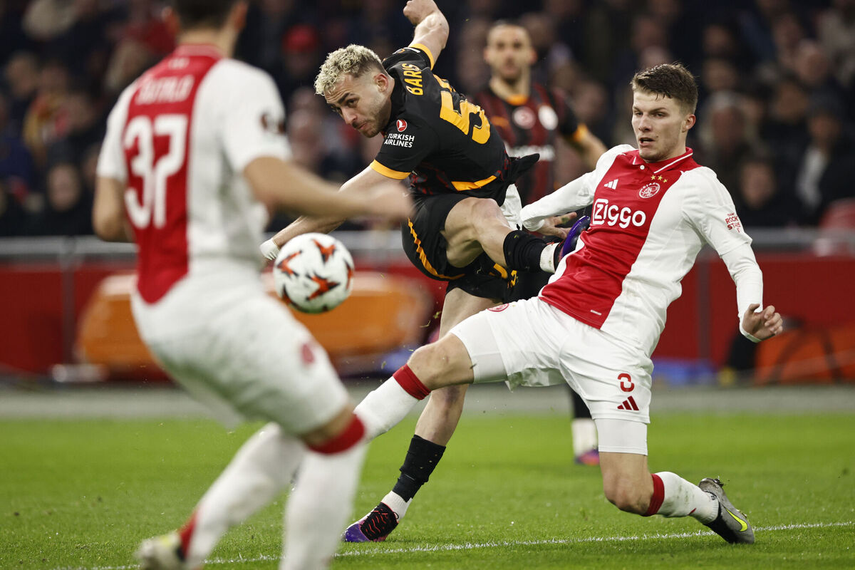 Galatasaray's Baris Yilmaz, background, tries his luck