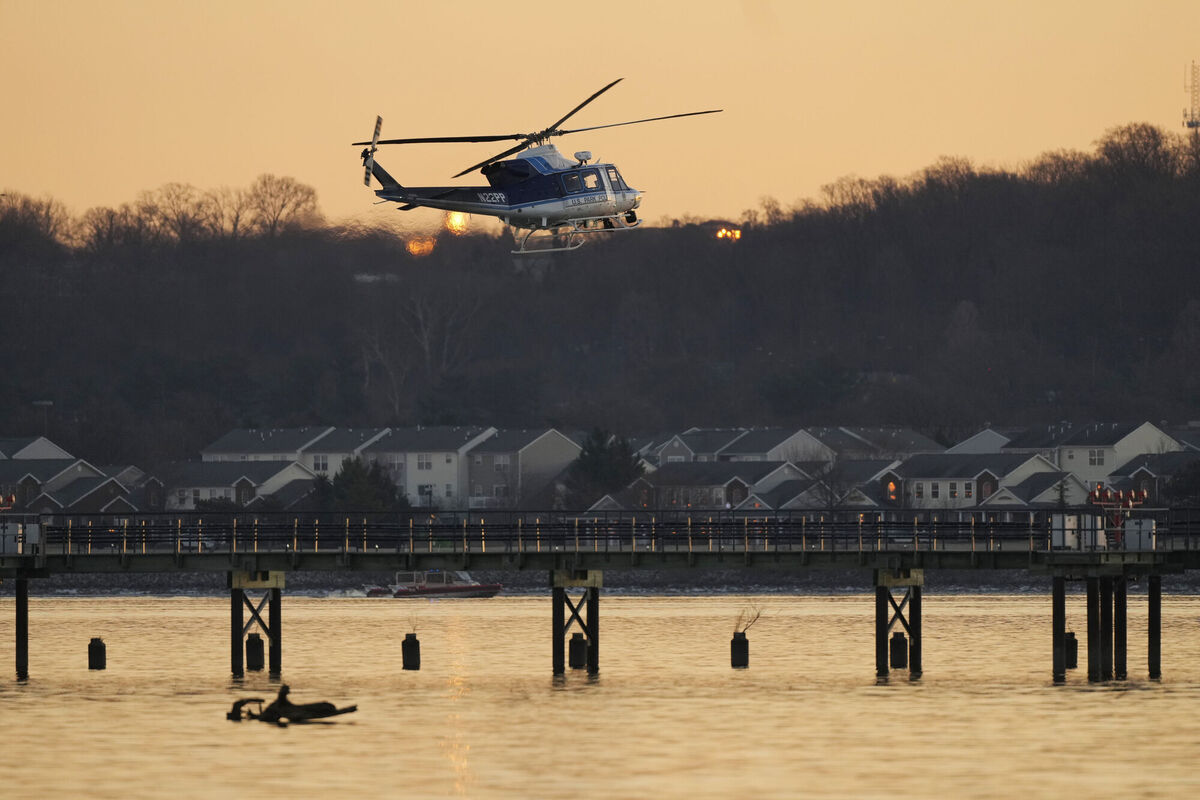 A US Park Police helicopter flies over the Potomac River near Ronald Reagan Washington National Airport, Thursday, Jan. 30, 2025, in Arlington, Va. (AP Photo/Carolyn Kaster)