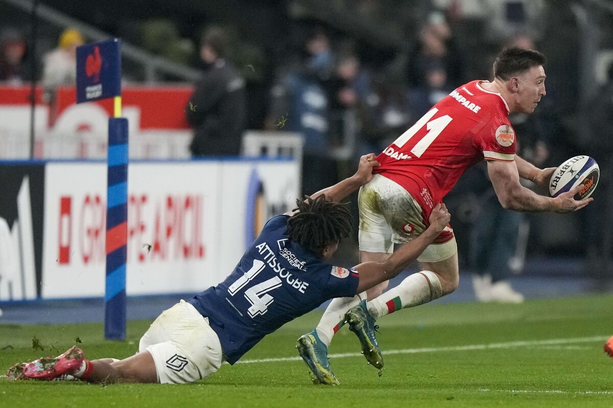 Wales' Josh Adams is tackled by France's Theo Attissogbe. Pic: AP Photo/Michel Euler.