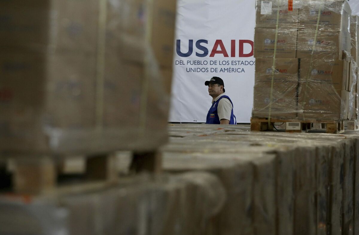 A man walks past boxes of USAID humanitarian aid at a warehouse at the Tienditas International Bridge on the outskirts of Cucuta, Colombia. Picture: Fernando Vergara A man walks past boxes of USAID humanitarian aid at a warehouse at the Tienditas International Bridge on the outskirts of Cucuta, Colombia. Picture: Fernando Vergara